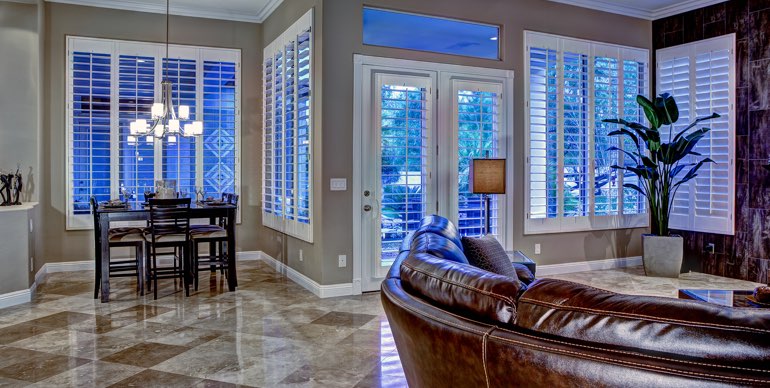 Southern California great room with white shutters and leather furniture.